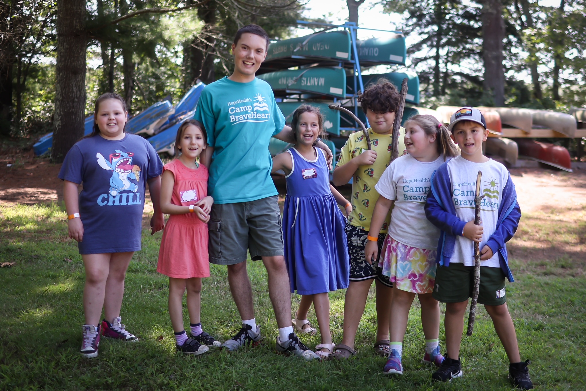 Camp Counselor standing with six young campers